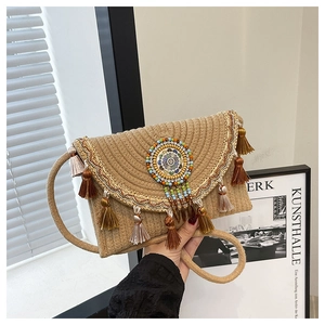 Close-up of bohemian woven straw bag with colorful tassels and embroidered beadwork