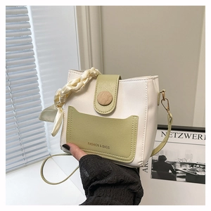 Detail of two-tone bucket bag with wooden buckle and decorative silk scarf detail