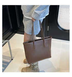 Side view of a vintage brown leather tote bag with long shoulder straps for daily commute