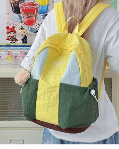 Detail of colorful nylon backpack featuring multi-color patchwork and embroidery