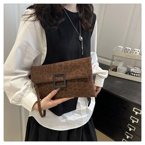 Detail of leopard print envelope clutch featuring a square buckle and matte texture