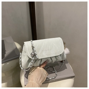 Détail du sac bandoulière plissé vert menthe avec chaîne en métal et pendentif peluche