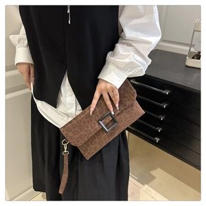 Detail of leopard print suede clutch bag with square buckle and wrist strap