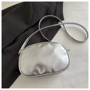 Detailed macro view of metallic silver leather texture and hardware on crossbody bag