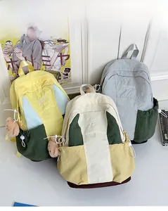 Detailed view of color-block nylon backpacks with embroidery and bear charms
