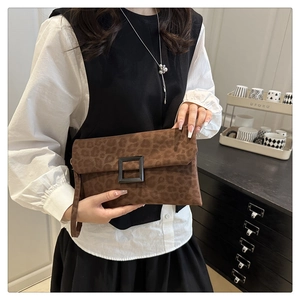Detail view of the brown leopard print faux suede clutch with a black square buckle