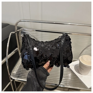 Dettaglio della borsa sottobraccio con paillettes nere e tracolla in pelle lucida