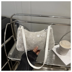 Dettaglio delle paillettes argento e pizzo bianco su una borsa a tracolla elegante