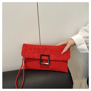 Macro view of a red leopard pattern envelope clutch bag with black matte metal buckle