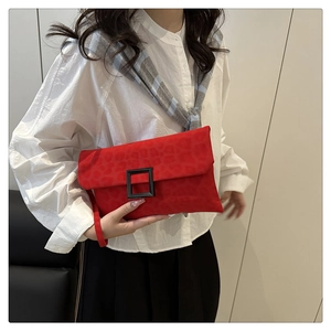 Detail of red leopard print clutch with matte black buckle and stylish wrist strap