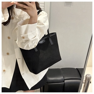 Mirror selfie showing the black tote bag with long handles for a stylish casual look