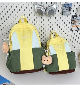 Detailed comparison of large and small nylon backpacks with tricolor patchwork design