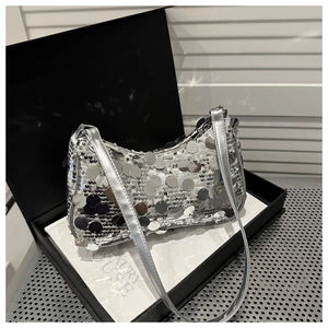 Dettaglio borsa a spalla in paillettes argento con grandi dischi su scatola regalo