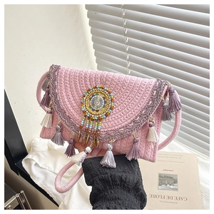Detail of pink woven envelope bag with purple tassels and decorative beadwork