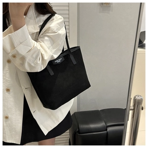 Detailed mirror selfie showing the fit and size of a black vintage canvas tote bag
