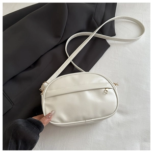 Detail of white oval crossbody bag with natural pleated texture and gold hardware zipper