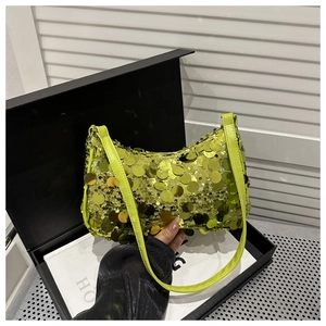 Dettaglio ravvicinato della borsa a spalla con paillettes verde lime in una scatola regalo