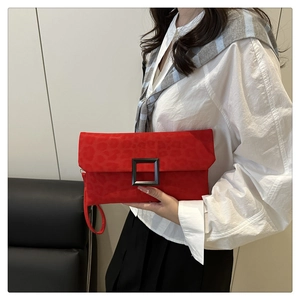 Detail of red leopard print suede underarm bag with black square buckle and slim wrist strap