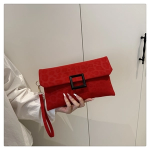 Detail of red leopard print envelope clutch with black square buckle and wrist strap