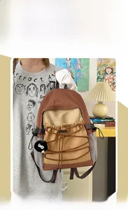 Detail of canvas backpack featuring drawstring pocket and coal sprite plush pendant