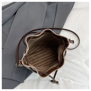 Detailed top view of drawstring bucket bag showing spacious striped lining and strap
