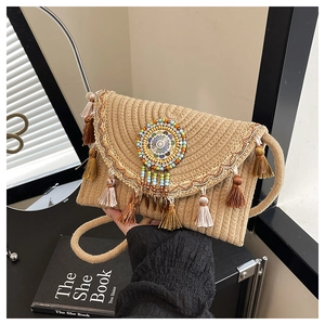 Detailed close-up of handmade straw bag with ethnic tassels and colorful beadwork