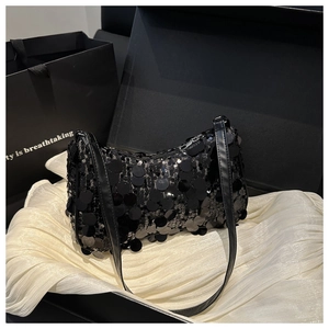 Dettaglio delle paillettes nere scintillanti su una borsa sottobraccio di lusso in pelle
