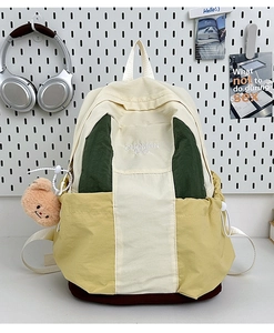 Detail of multi-color nylon backpack with side drawstring and cute brown bear charm