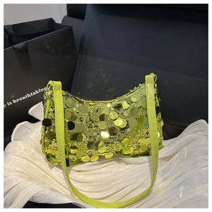 Dettaglio delle paillettes verdi sulla borsa a tracolla con cinturino in pelle