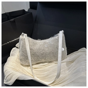 Dettaglio di una borsa hobo con paillettes bianche su seta satinata bianca