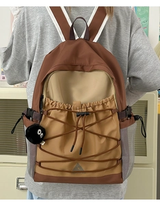Detail of color-block canvas backpack with elastic drawstrings and plush pendant
