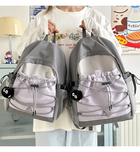 Detail of grey-purple canvas backpack with elastic cord and mesh pocket close-up