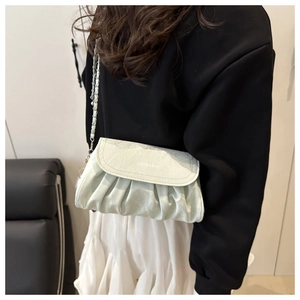 Detail of mint green pleated cloud bag with chain strap and Fashion & Bags lettering