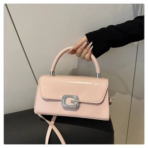 Detail of pink glossy leather handbag with sparkling silver G-shaped rhinestone lock