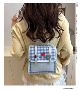 Detail of light blue plaid backpack with apple embroidery and stylish shoulder straps