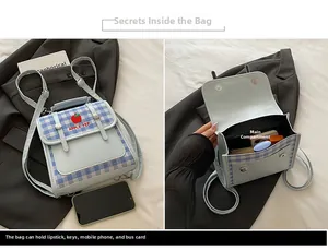 Detail view of mini plaid backpack with apple embroidery and internal storage capacity