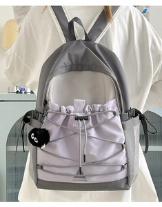 Detail view of large capacity canvas backpack featuring color-block design and elastic cords