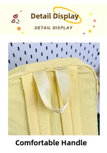 Detail view of the reinforced top handle on a yellow nylon collegiate backpack
