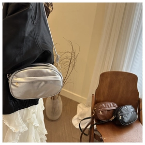 Three colors of minimalist oval crossbody bags in silver, black and brown leather