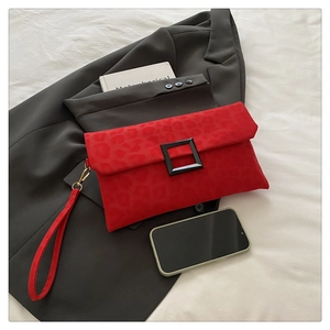 Detail of red leopard print envelope clutch bag with black square buckle and wristlet