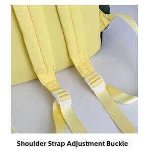 Detail of adjustable shoulder straps with white plastic buckles on yellow nylon backpack