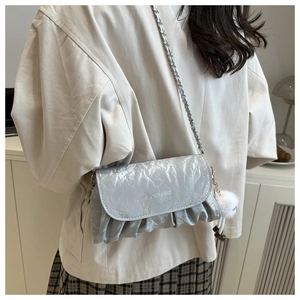 Detail view of silver pleated cloud bag with metallic chain and white fur charm decoration