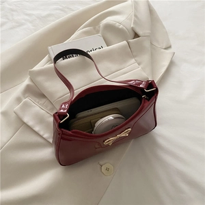 Borsa a spalla baguette rosso scuro alla moda con fiocco dorato e interno capiente