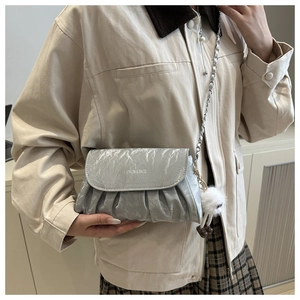 Silver pleated chain shoulder bag with plush charm shown on a fashion model