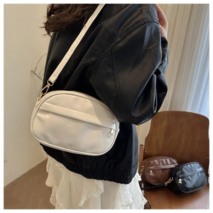 Close-up of high-quality ivory faux leather crossbody bag with adjustable wide shoulder strap