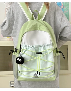 Outdoor light green canvas backpack with contrast stitching and mesh side pockets