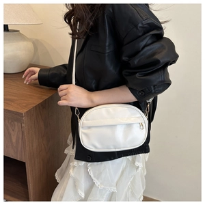 Detail of white PU leather crossbody bag with gold metal zipper and slim shoulder strap