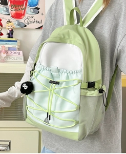 Detail of color-block canvas backpack with large drawstring pocket and side mesh pocket