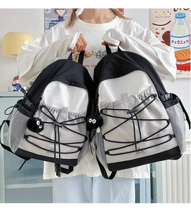 Detail of color-block canvas backpack with elastic bungee cords and side mesh pockets