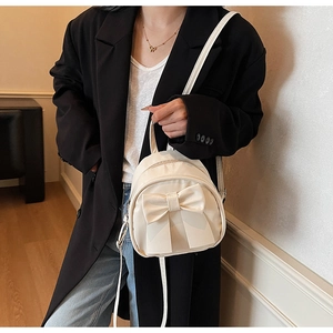 Detail view of cream mini backpack with large bow decoration and fine PU leather straps